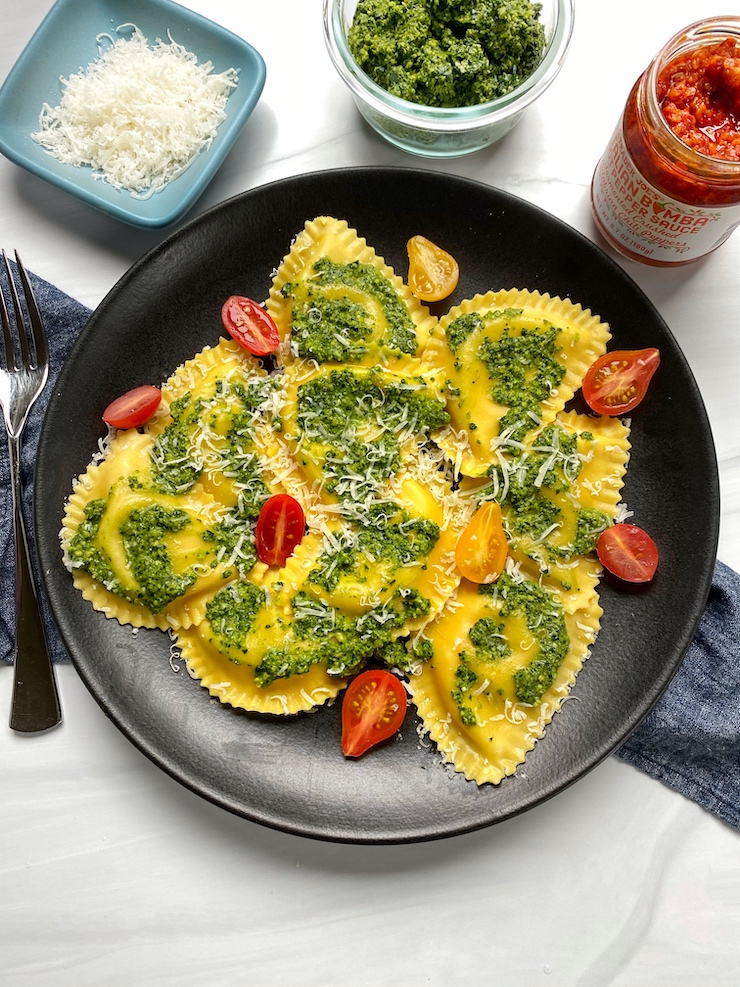 Roasted cauliflower and cheese pesto on a black plate with kale pesto.