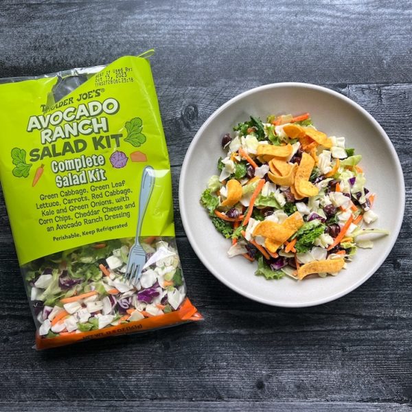 Trader Joe's Avocado Ranch Salad in a white bowl  arranged alongside the salad kit bag. 