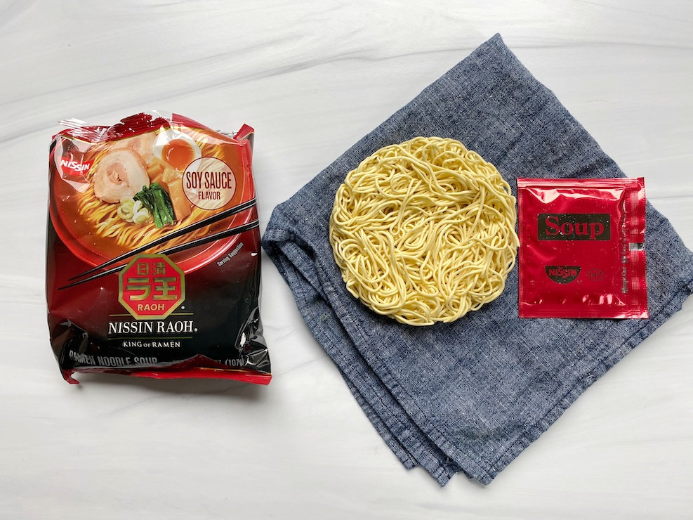 Nissin Raoh ramen soy sauce flavor noodles and sauce packet.