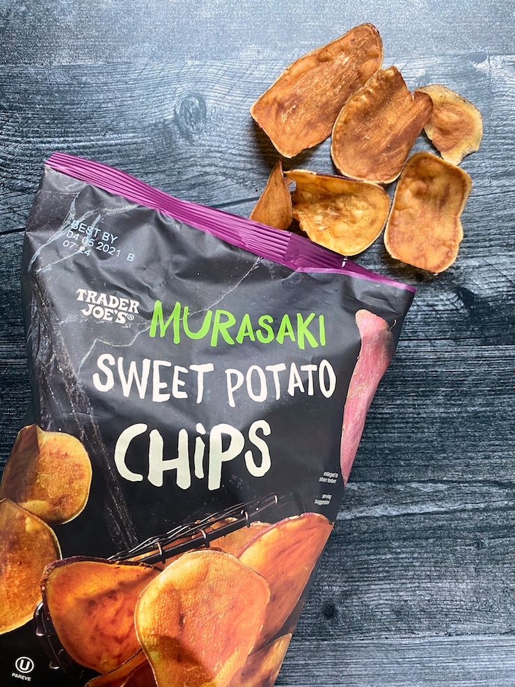 A bag of Trader Joe's Murasaki Sweet Potato Chips with a pile of chips coming out of the top right corner of the bag. 
