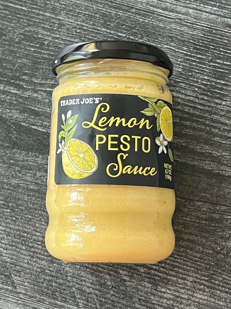 Trader Joe's Lemon Pesto jar laying down on a weathered wood background