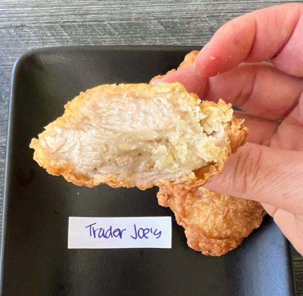 Cross section of a piece of karaage shown against a black plate and labeled Trader Joe's .