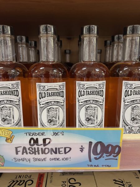 Bottles of Trader Joe's Old Fashioned Cocktail on shelves in a trader joes' store.