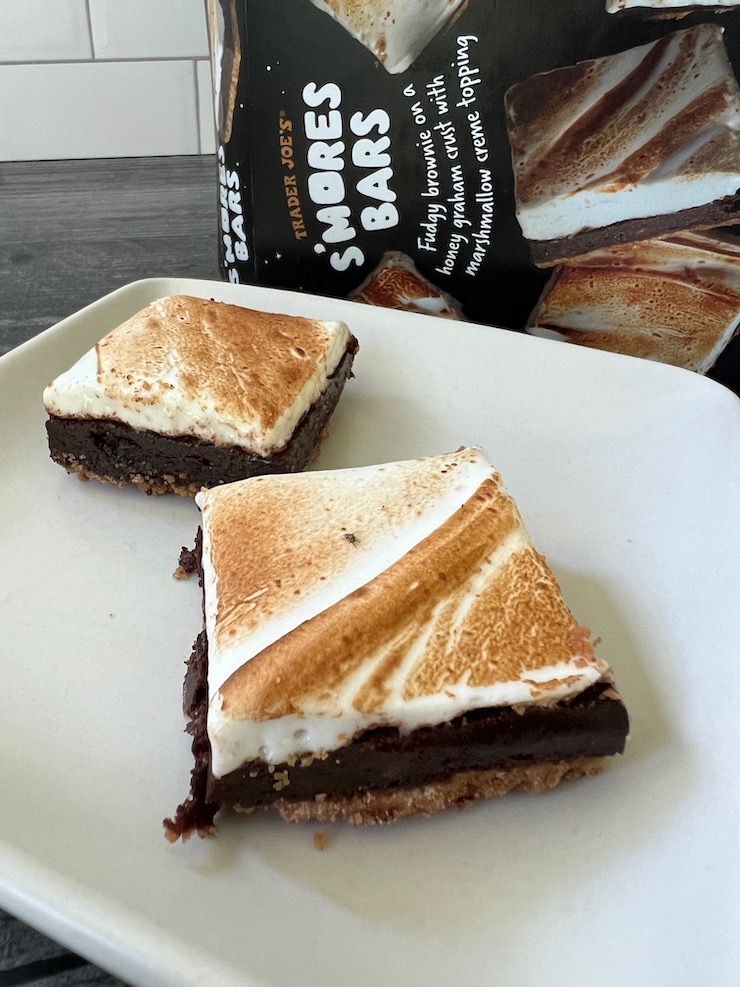 3/4 view of the smores on a white plate, showing the graham, brownie and marshmallow layers. 
