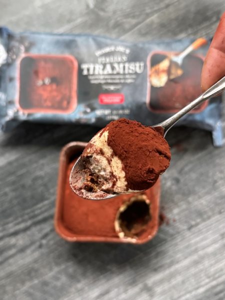 Trader Joe's Italian Tiramisu scooped on a spoon with the package in the background.