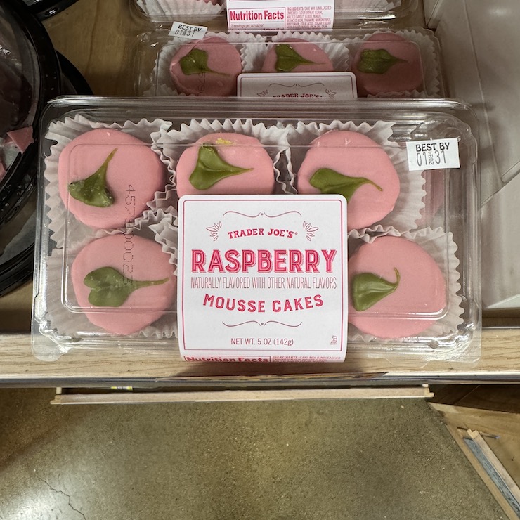 Trader Joe's mini raspberry mousse cakes with pink frosting and a green leafy shape on top. Some people might see it as a heart.