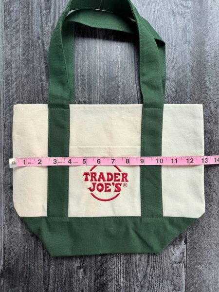 Trader Joe's Small Canvas tote with green accents with a measuring tape showing 13 inches wide