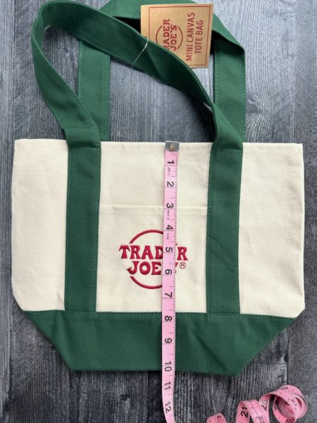 Trader Joe's Small canvas tote with green accents with a measuring tape showing roughly 10.25 inches high