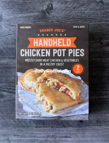 Trader Joe's Handheld Chicken Pot Pies box on a grey weathered wood background.