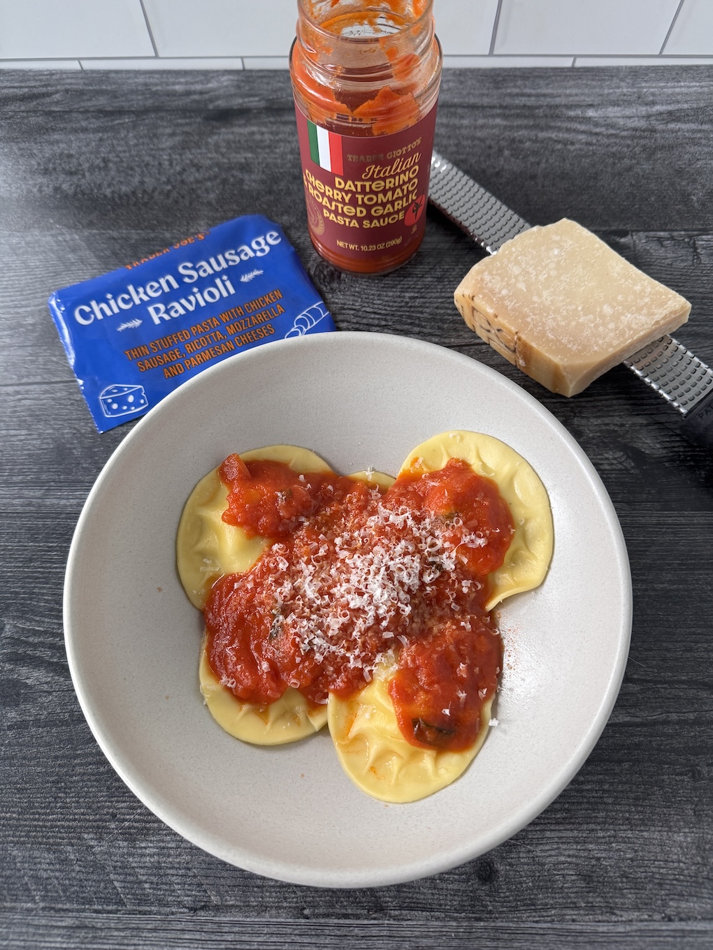 Trader Joe's Chicken Sausage Ravioli served in a white bowl with marinara and topped with parm